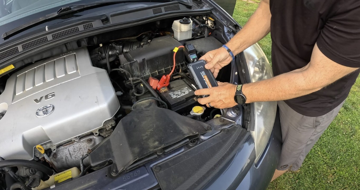 Technician performing battery jump-start service on vehicle in Herriman, UT